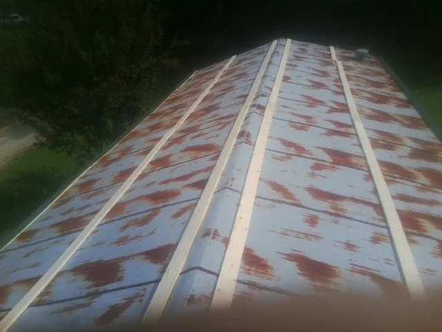 Rusted metal roof panels with new wood purlins before replacement — Storm Damage Roof Repair in New Salem by Roofing Brothers